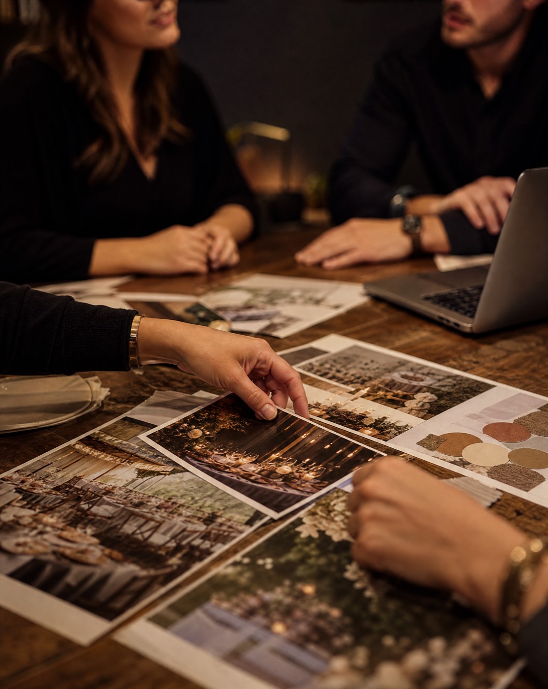 Hands reviewing venue photographs and a mood board during an event planning consultation